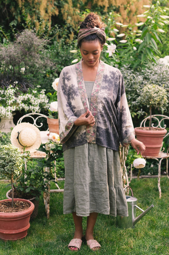 Model wearing our Still I Rise Pixie Duster with empowering message a bold, layered design featuring antique landscape etchings – Market of Stars