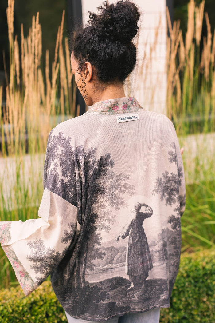 Model wearing our Still I Rise Pixie Duster with empowering message a bold, layered design featuring antique landscape etchings – Market of Stars