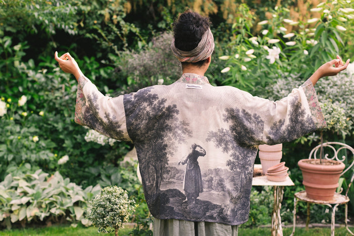 Model wearing our Still I Rise Pixie Duster with empowering message a bold, layered design featuring antique landscape etchings – Market of Stars