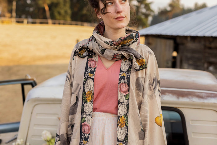 Model wearing Take My Hand scarf with 1600s hand engraving of clasped hands, a painted heart, florals and sun rays – Market of Stars