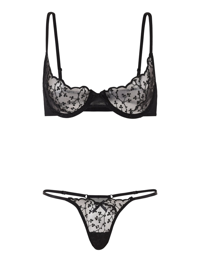 The TALIYAH SET - BLACK by TIGERMIST features an underwire bra with floral lace detailing and adjustable straps, paired with a matching low-rise g-string adorned with the same lace floral pattern. The set is showcased against a plain white background.