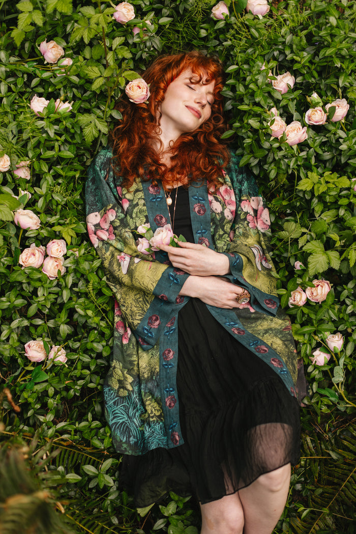Model wearing a mid-length duster robe ft. hand-coloured etching from the 1880s called The Bower of Roses - Market of Stars