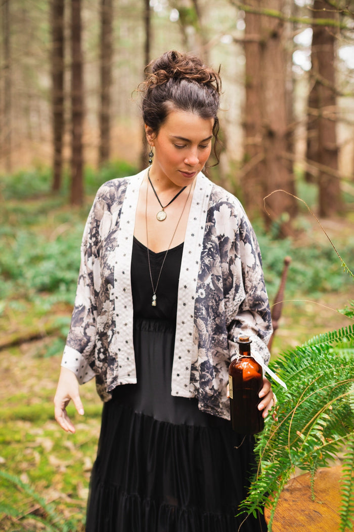 Model wearing Looking Glass Cropped Kimono featuring grown-up Alice Liddell, rare Victorian botanicals, and celestial star and moon accents inspired by Wonderland – Market of Stars.