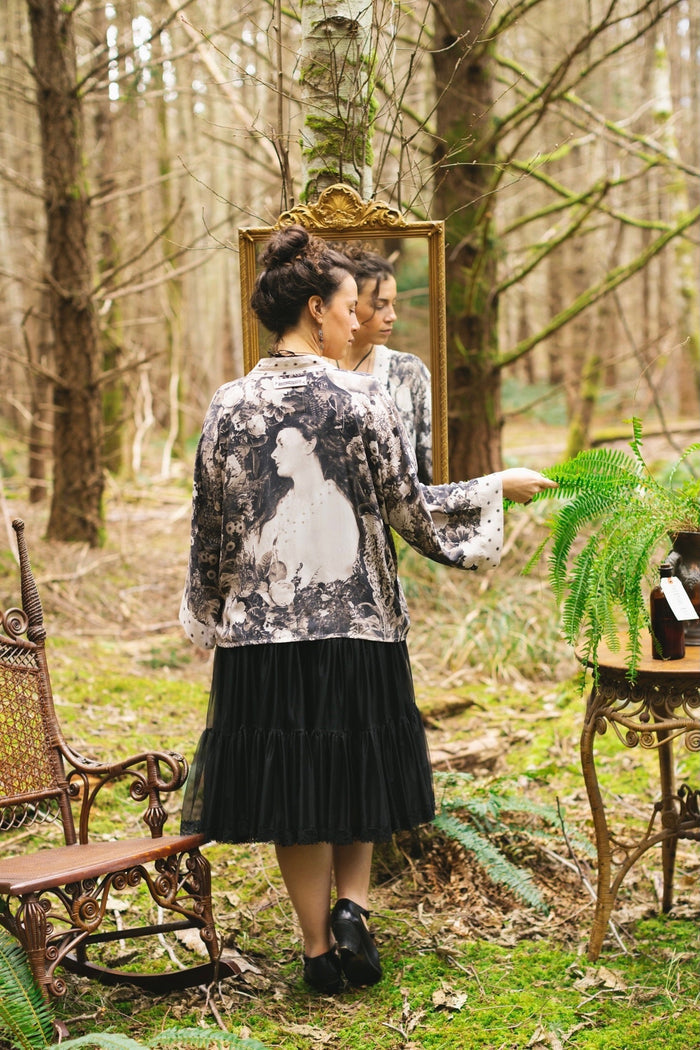 Model wearing Looking Glass Cropped Kimono featuring grown-up Alice Liddell, rare Victorian botanicals, and celestial star and moon accents inspired by Wonderland – Market of Stars.