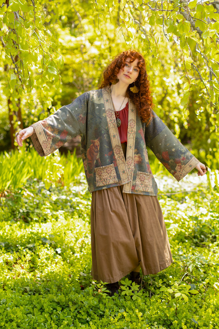 Model wearing a cozy cardigan lined with fleece featuring florals from centuries-old paintings and Rosetti’s iconic portrait of Joan of Arc - Market of Stars