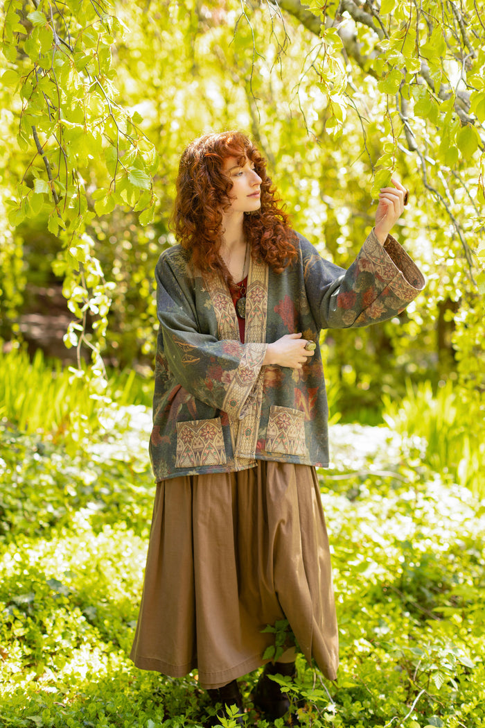 Model wearing a cozy cardigan lined with fleece featuring florals from centuries-old paintings and Rosetti’s iconic portrait of Joan of Arc - Market of Stars
