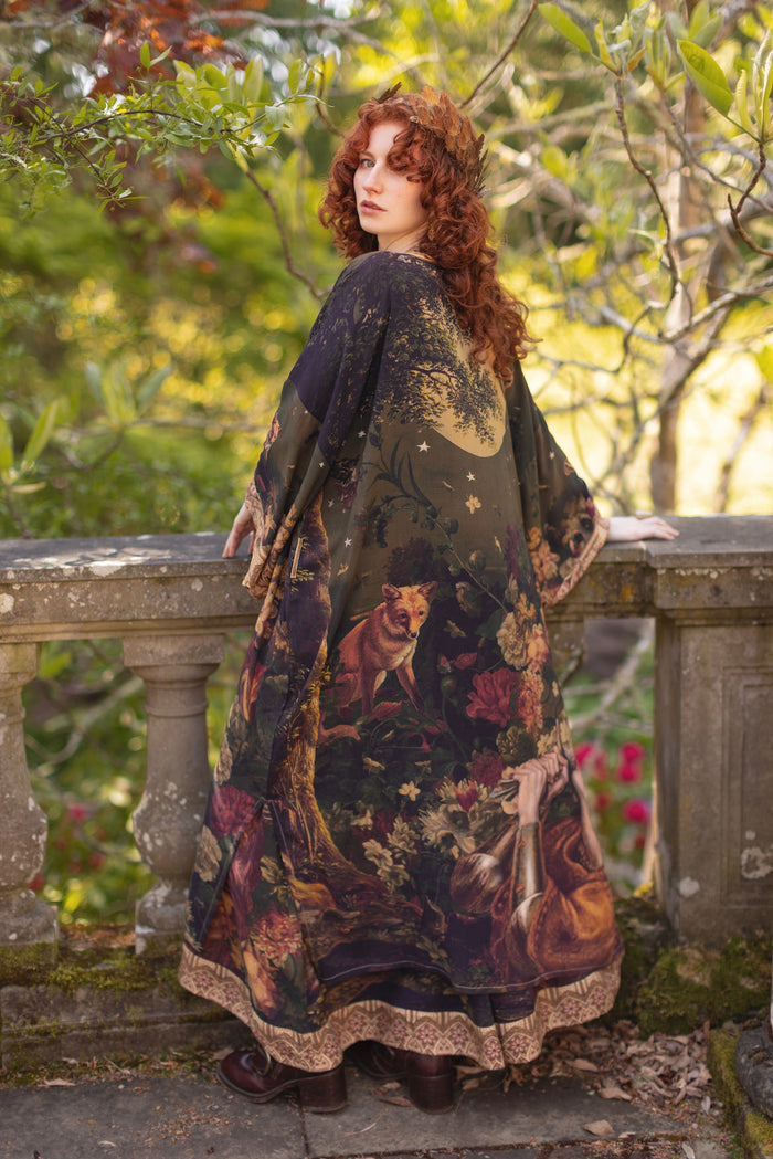 Model wearing a full-length bamboo-viscose duster featuring florals from centuries-old paintings and Rosetti’s iconic portrait of Joan of Arc - Market of Stars