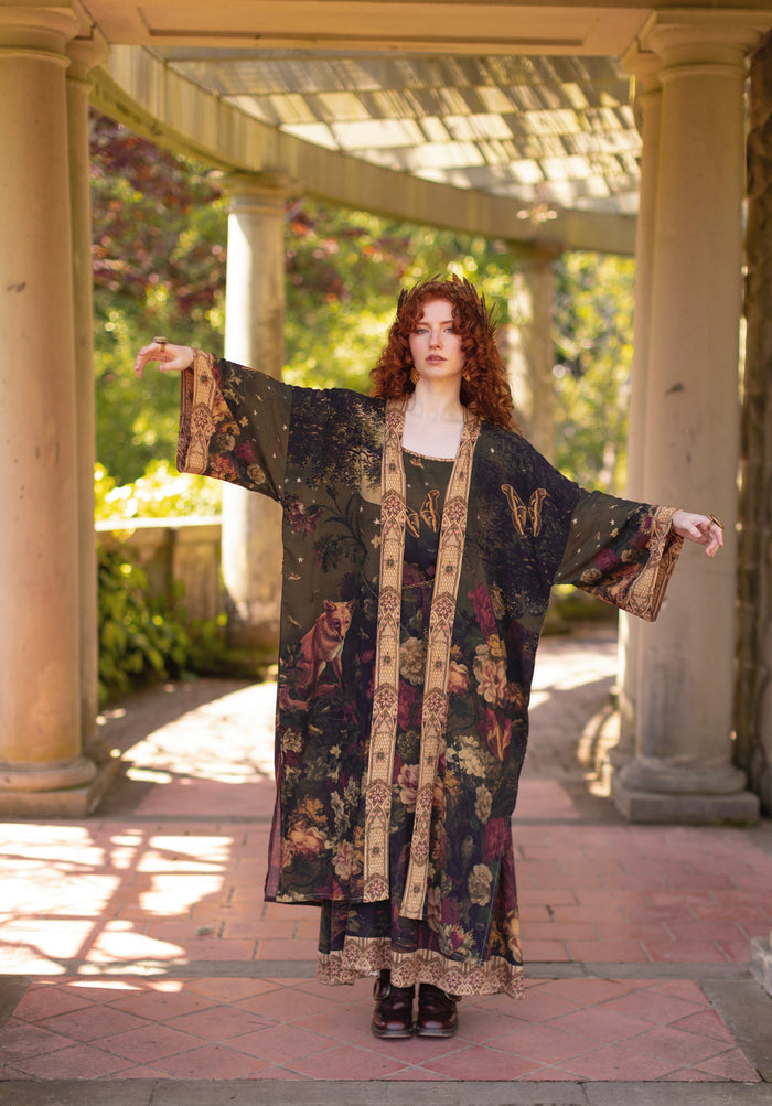 Model wearing a full-length bamboo-viscose duster featuring florals from centuries-old paintings and Rosetti’s iconic portrait of Joan of Arc - Market of Stars