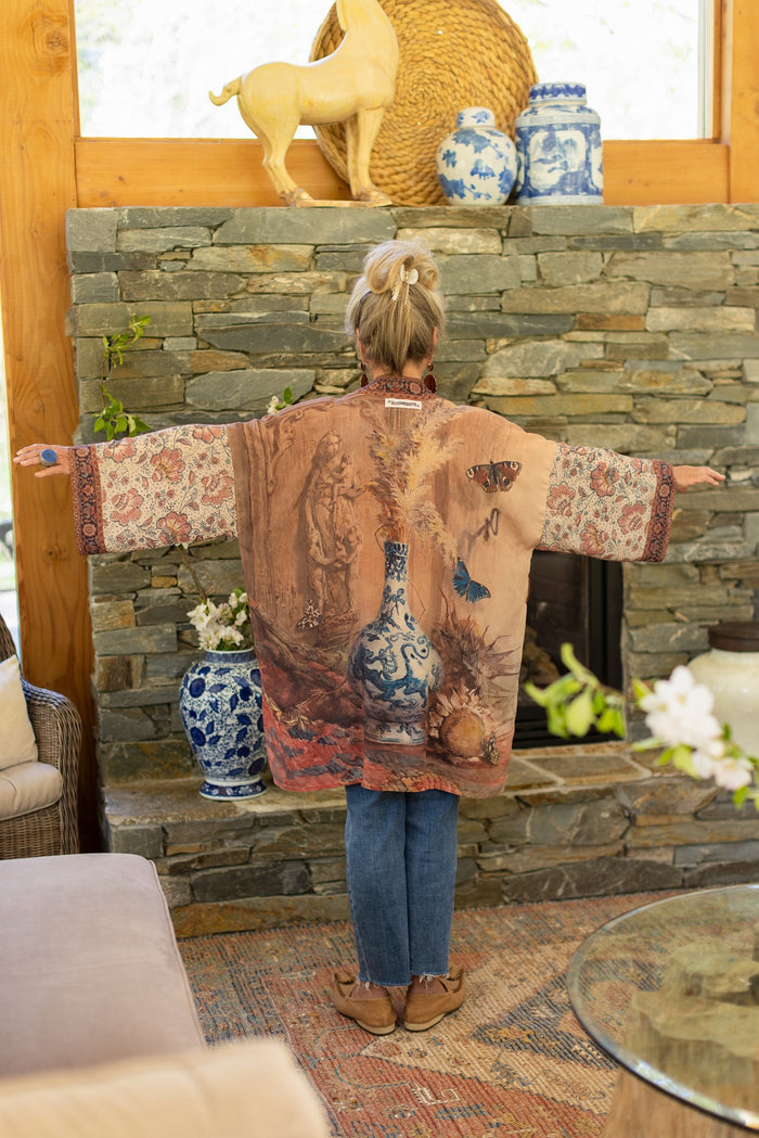 Model(s) wearing The Storyteller -- a mid-length Matinée kimono duster featuring antique artwork and vintage prints from around the world -- Market of Stars