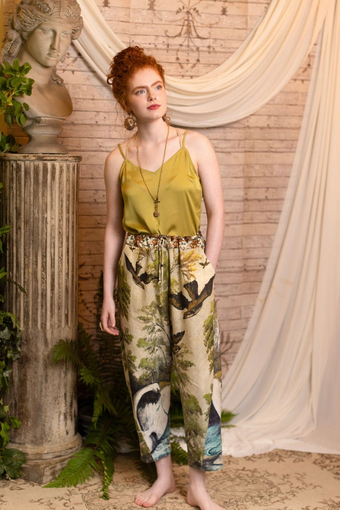 Model wearing Theatre of Dreams Artist Pants with lantern-hem silhouette featuring antique landscape, swan, and painted birds by artist Jennifer Lanne