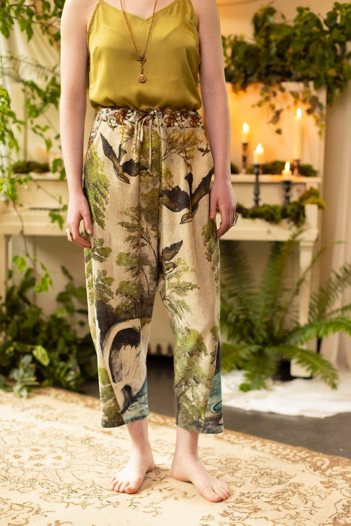 Model wearing Theatre of Dreams Artist Pants with lantern-hem silhouette featuring antique landscape, swan, and painted birds by artist Jennifer Lanne