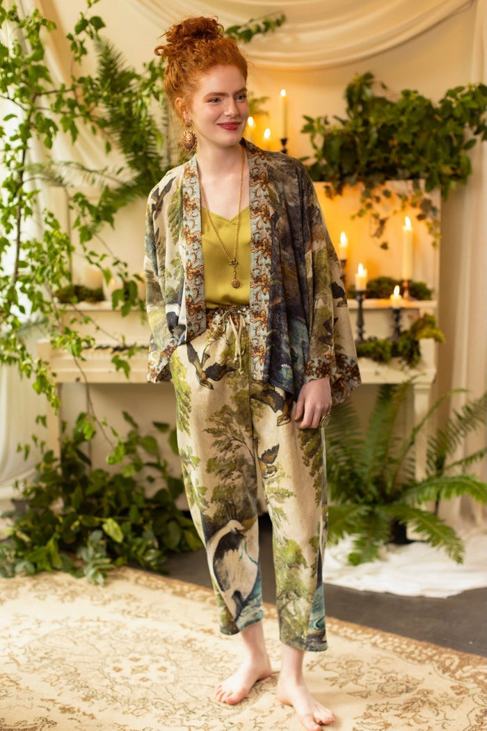 Model wearing Theatre of Dreams Artist Pants with lantern-hem silhouette featuring antique landscape, swan, and painted birds by artist Jennifer Lanne