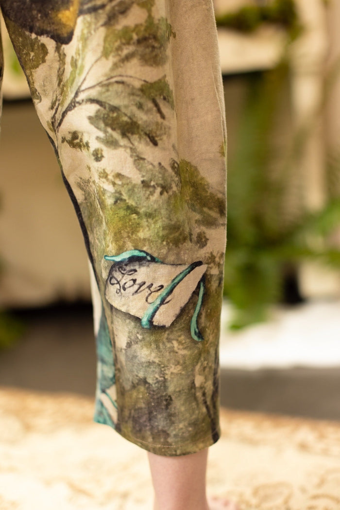 Model wearing Theatre of Dreams Artist Pants with lantern-hem silhouette featuring antique landscape, swan, and painted birds by artist Jennifer Lanne