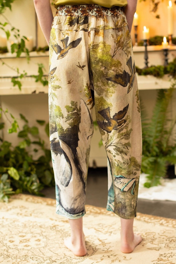 Model wearing Theatre of Dreams Artist Pants with lantern-hem silhouette featuring antique landscape, swan, and painted birds by artist Jennifer Lanne