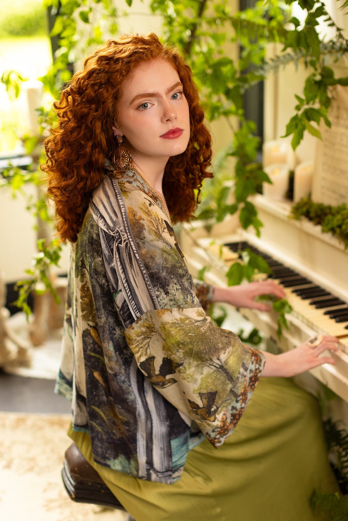 Model wearing the cropped Theatre of Dreams kimono featuring painted swan, antique script, and whimsical theatre imagery from artist Jennifer Lanne