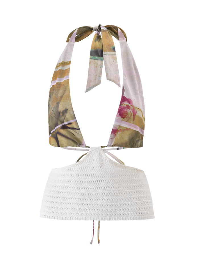The TILLEY TOP - ROSE POSTCARD by TIGERMIST is a halter crop crochet top with a floral mesh scarf-style upper, white crocheted bottom, open back, and adjustable neck tie.