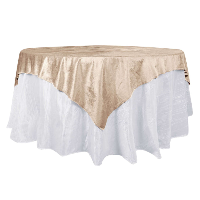 Round table covered with a beige velvet tablecloth on a white table skirt