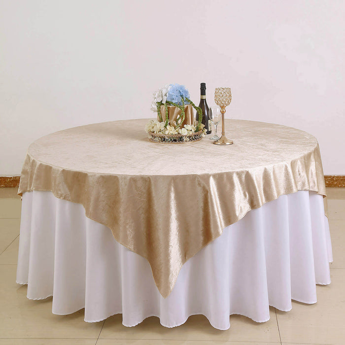 Elegant round table with champagne color tablecloth and decorative centerpiece.