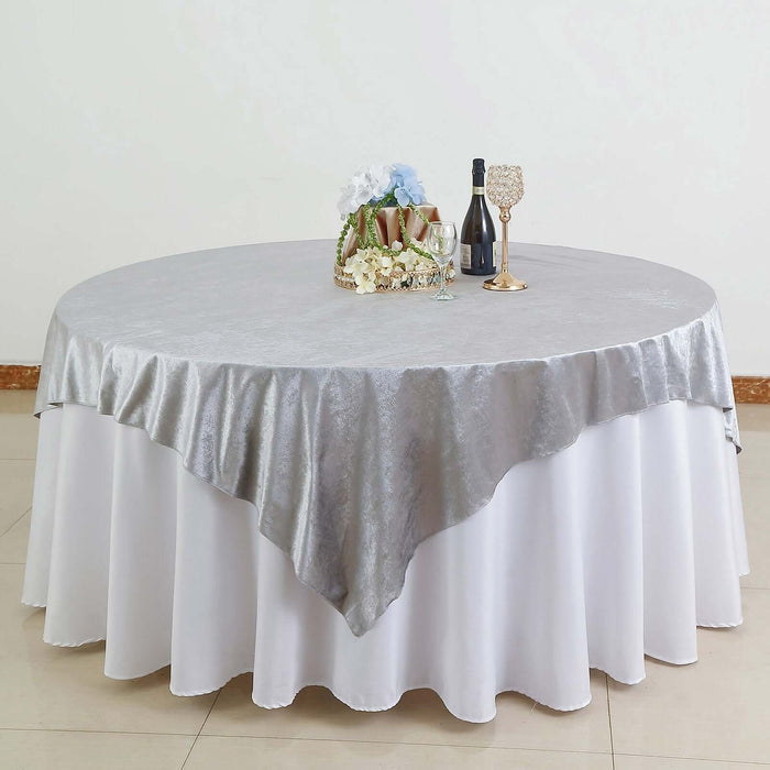 Silver tablecloth draped elegantly over a round table with decorative items.