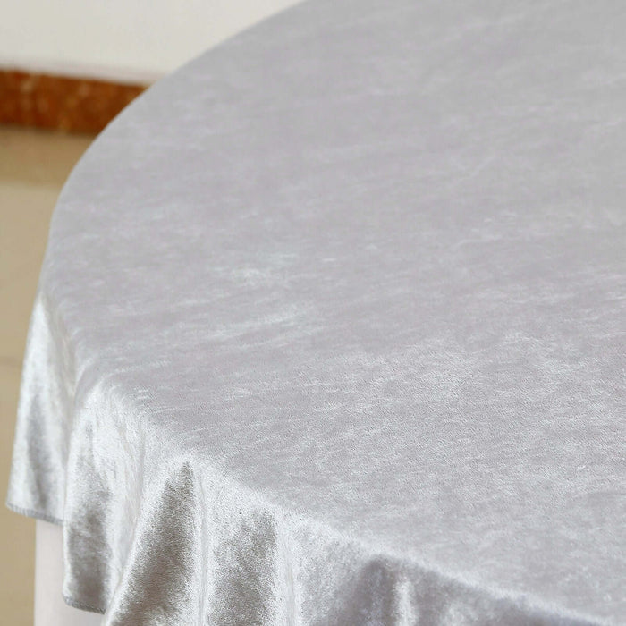 Silver velvet tablecloth on a round table.