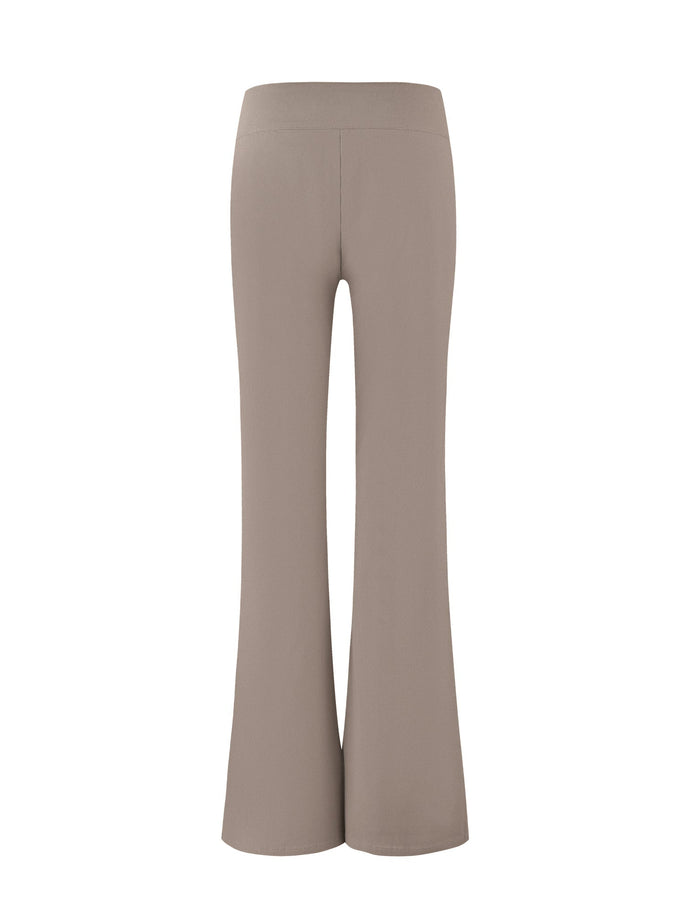 A pair of VESPER PANT - BROWN : TAN from TIGERMIST is shown. The solid tan, high-waisted flare pants have a smooth, seamless design with a wide waistband and a slightly flared leg, tailored for a sleek and stylish fit. The image captures the rear view of the fitted silhouette.