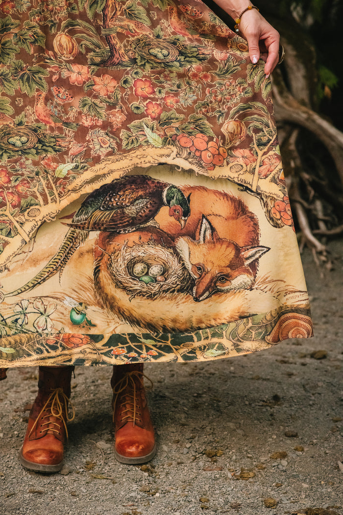Model wearing a bamboo-viscose maxi length slip dress where even the unlikeliest of friends...a fox and a pheasant...find warmth in each other’s company. Created in collaboration with Charles van Sandwyck - Market of Stars
