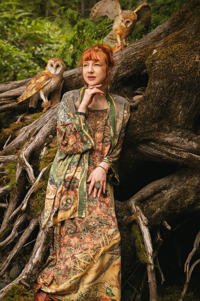 Model wearing a bamboo-viscose maxi length slip dress where even the unlikeliest of friends...a fox and a pheasant...find warmth in each other’s company. Created in collaboration with Charles van Sandwyck - Market of Stars