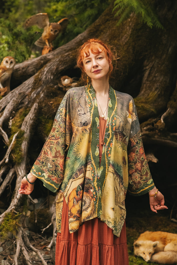 Model wearing a bamboo-viscose mid-length duster kimono robe where even the unlikeliest of friends...a fox and a pheasant...find warmth in each other’s company. Created in collaboration with Charles van Sandwyck - Market of Stars