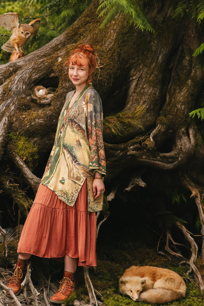 Model wearing a bamboo-viscose mid-length duster kimono robe where even the unlikeliest of friends...a fox and a pheasant...find warmth in each other’s company. Created in collaboration with Charles van Sandwyck - Market of Stars