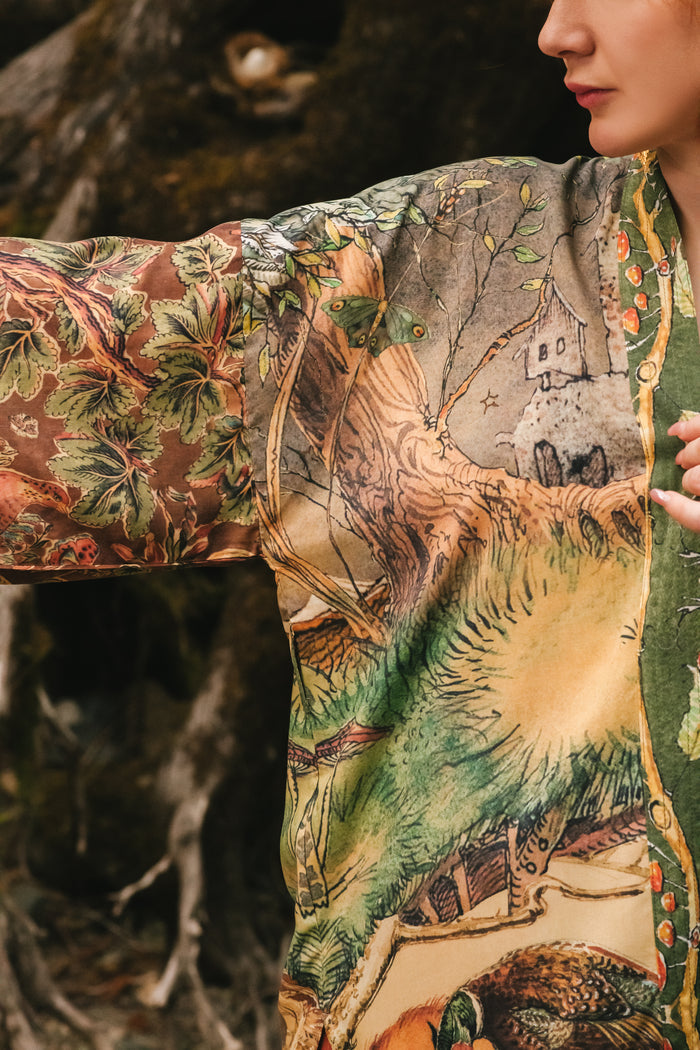 Model wearing a bamboo-viscose mid-length duster kimono robe where even the unlikeliest of friends...a fox and a pheasant...find warmth in each other’s company. Created in collaboration with Charles van Sandwyck - Market of Stars
