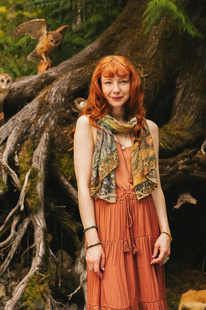 Model wearing a bamboo-viscose scarf where a noble rabbit rests deep within an underground burrow, surrounded by the warmth and safety of the earth. Created in collaboration with Charles van Sandwyck - Market of Stars